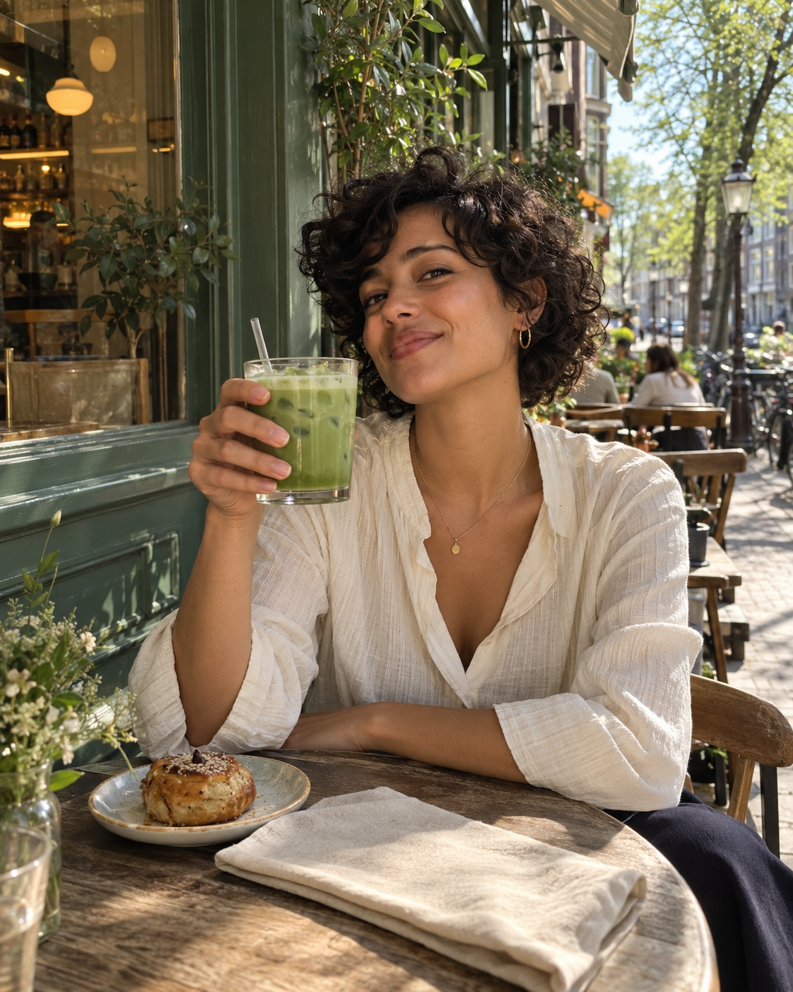 Fictieve creator met een iced matcha op een zonnig Amsterdams caféterras